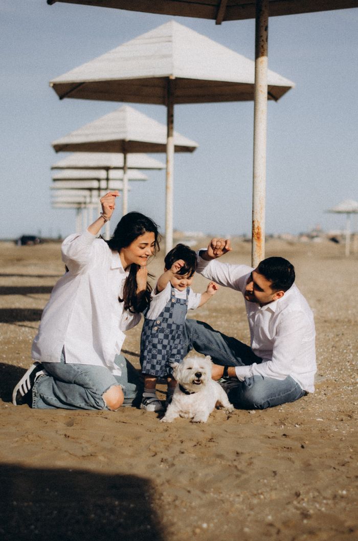 Family playing with dog on a sunny Baku beach. Perfect vacation vibe.