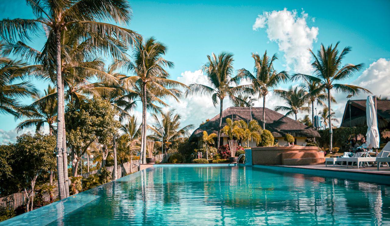 Scenic view of a luxury tropical resort with palm trees and an inviting pool.